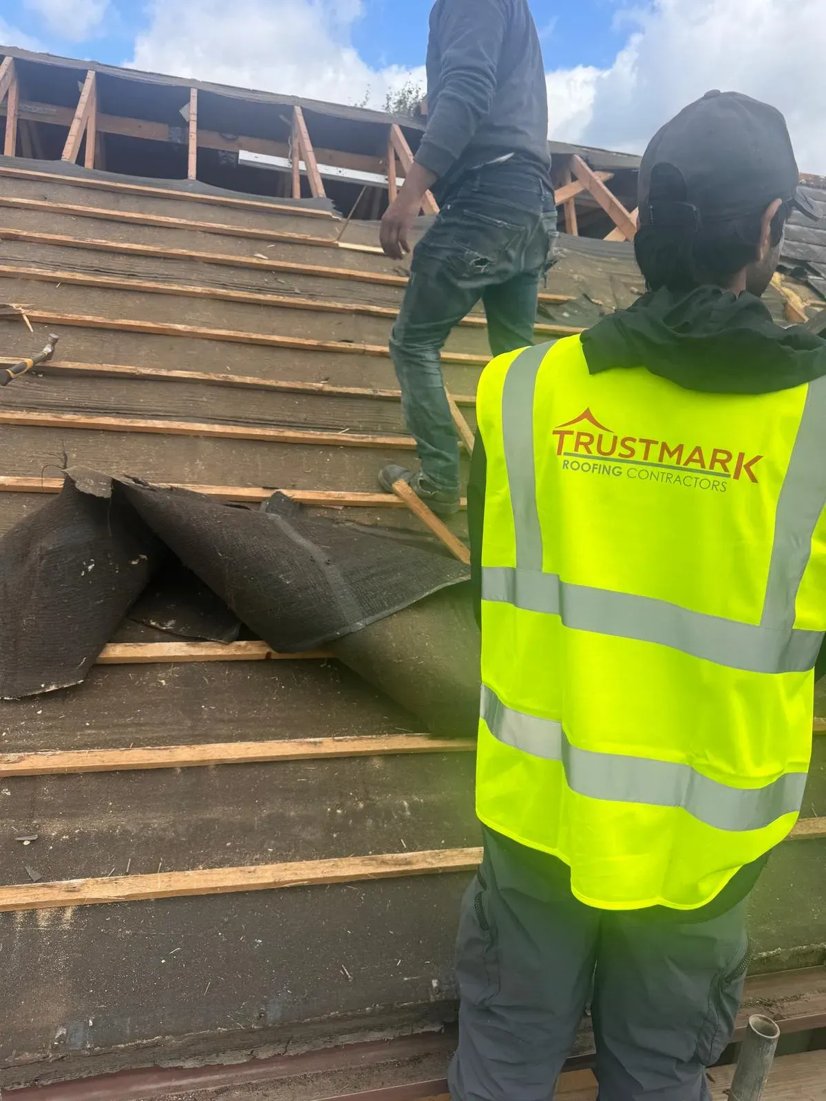 Trustmark Roofing contractors installing a new roof or performing a major roof repair, showing the roof structure, battens, and underlayment.
